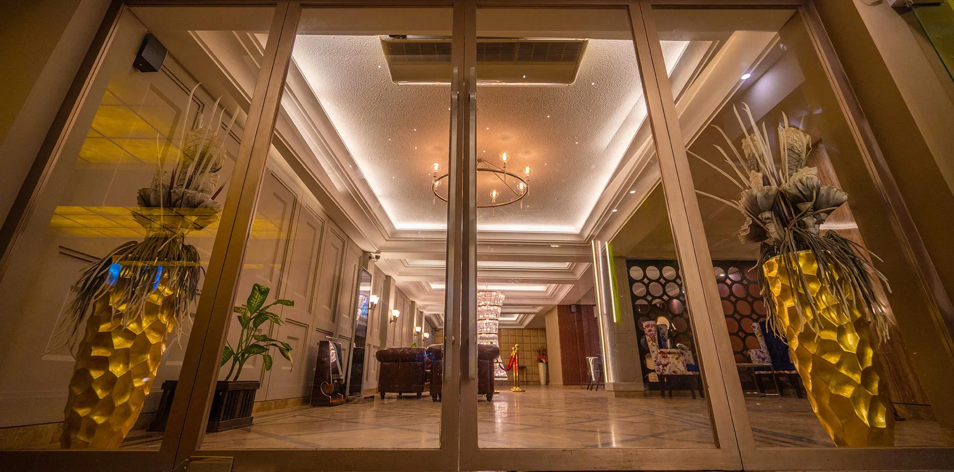Lobby entrance seen through glass doors with chandelier lighting