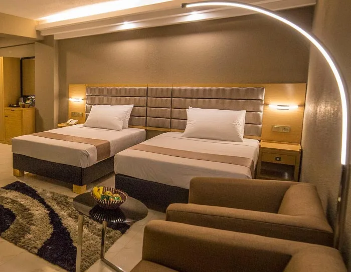 Twin guest room with a sofa and an arched floor lamp