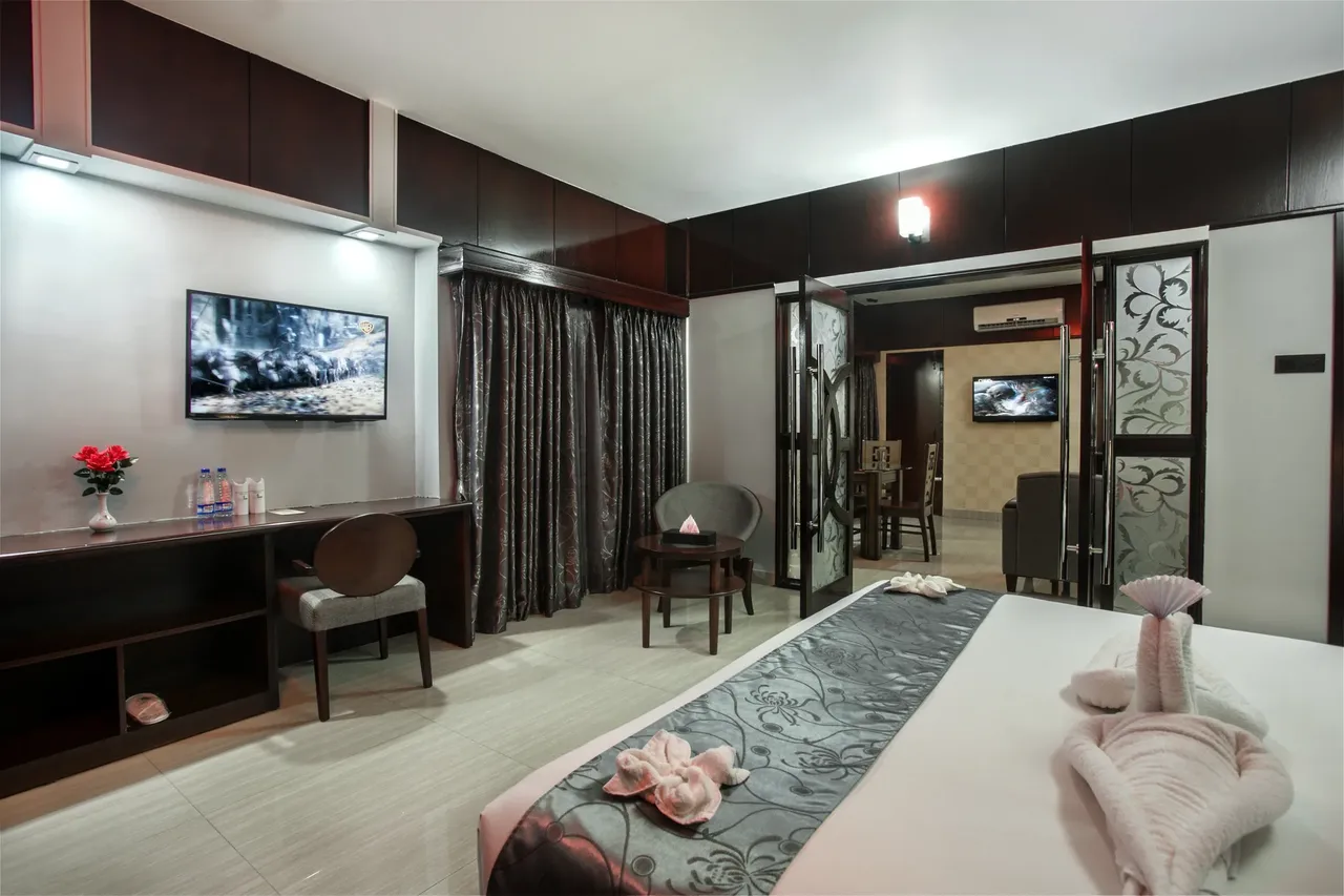 Suite bedroom with a large bed and a television