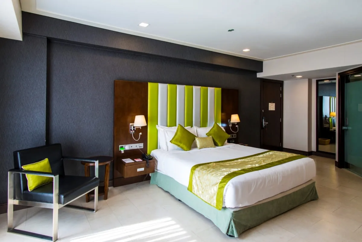 Room with a double bed and a green striped headboard at Platinum Grand