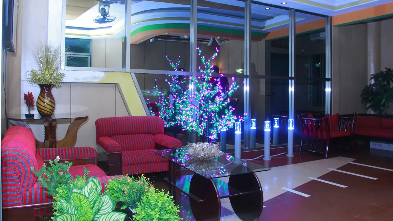 Lobby seating area with red sofas and a lit decorative tree