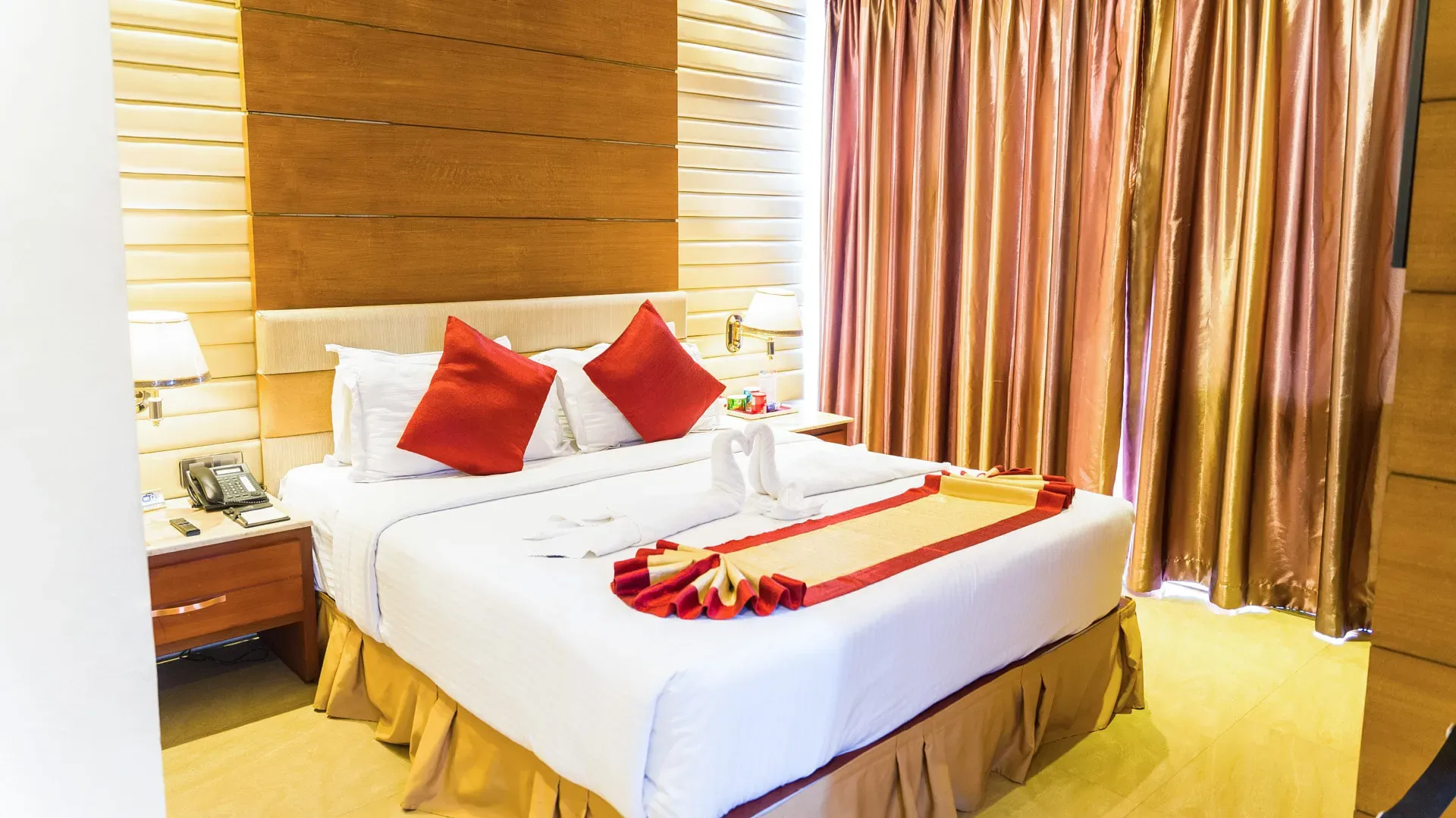 Guest room with a king bed and red cushions at FARS Hotel & Resorts
