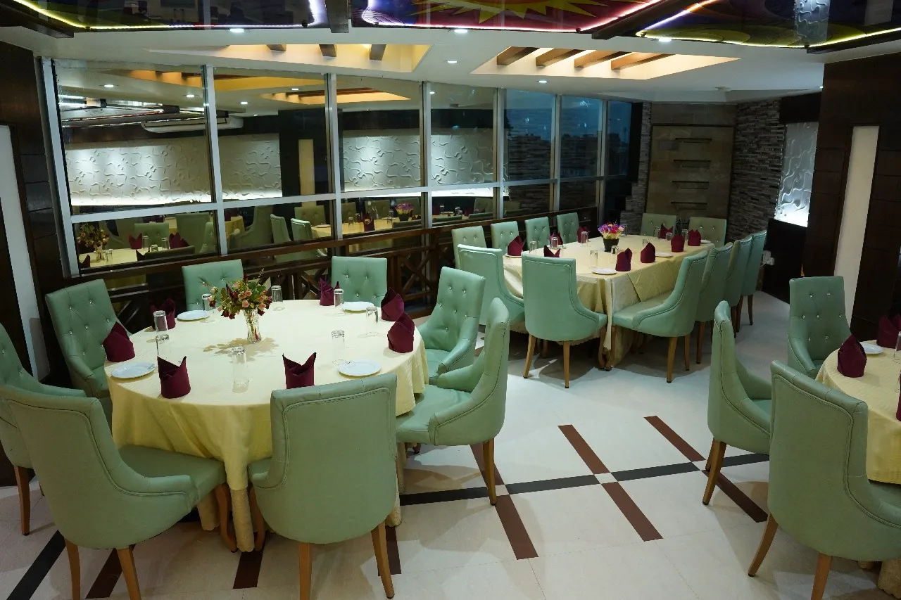 Restaurant with round tables and green chairs