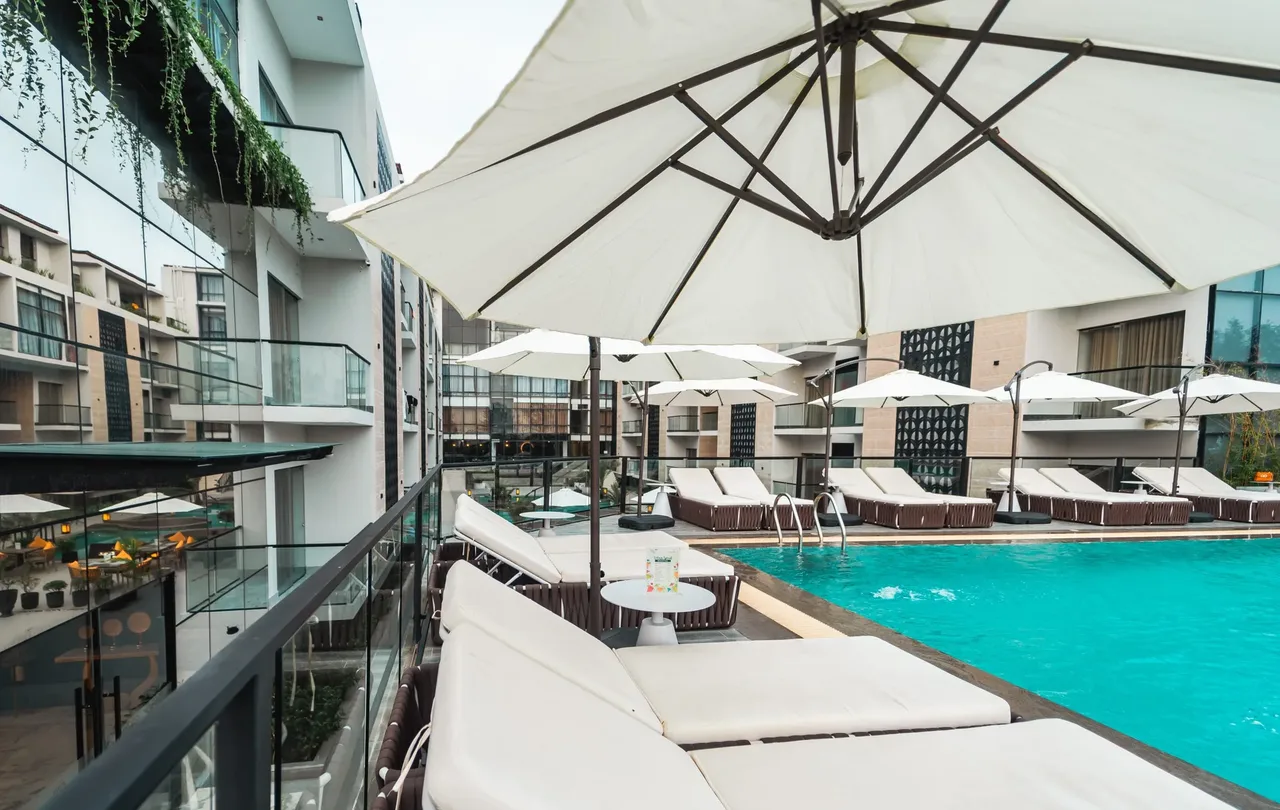 Pool deck with umbrellas at Green Nature Resort & Suites