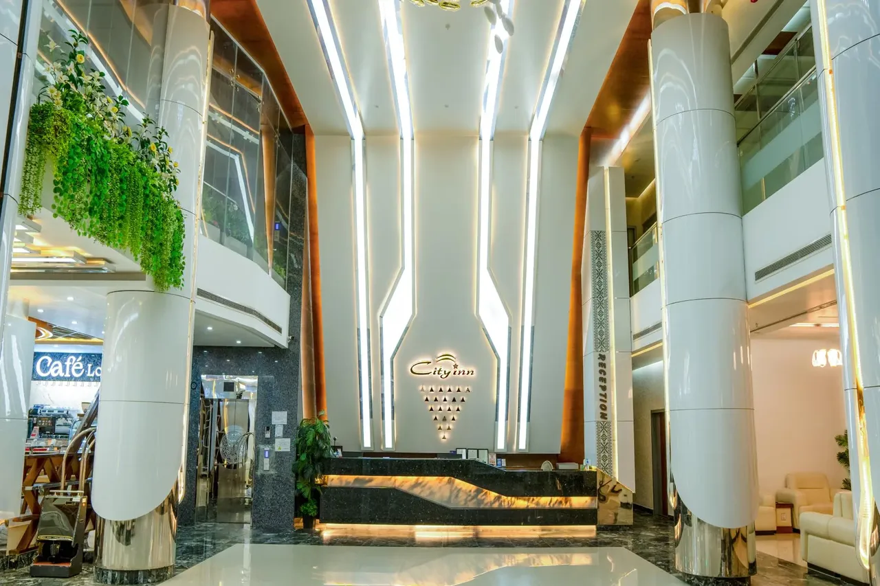 Lobby with a reception desk, tall columns and a Café Lounge sign