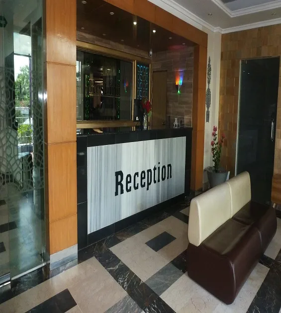 Reception desk with a wood-panelled wall and marble floor