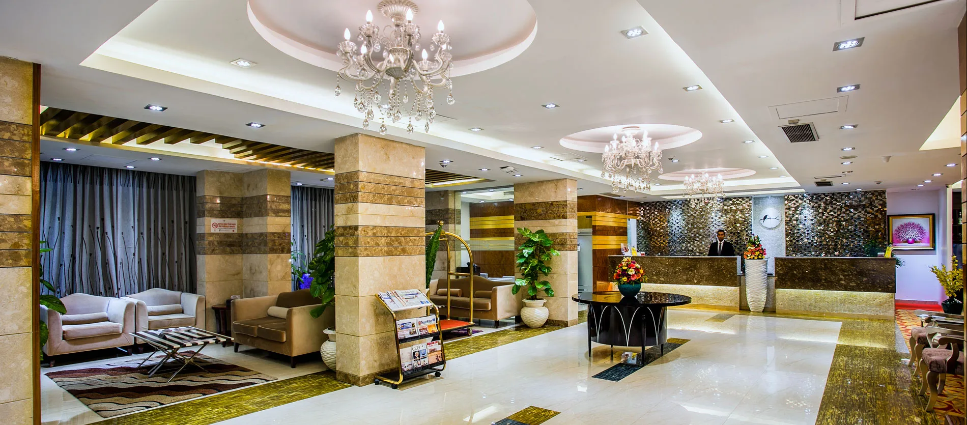 Lobby with chandeliers and stone-clad columns at Hotel Bengal Blueberry