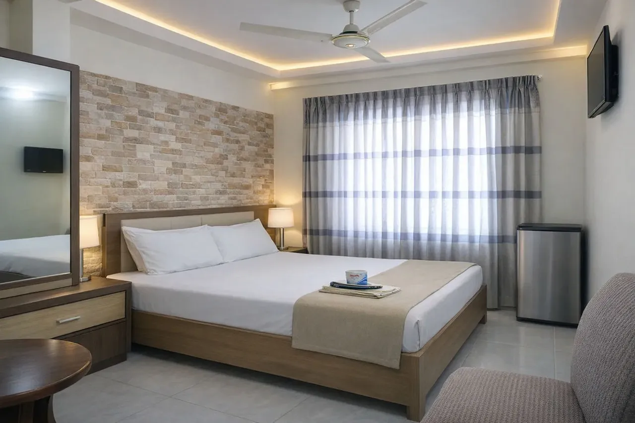 Double guest room with a window and wall-mounted TV