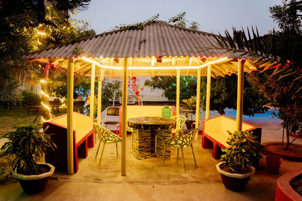 Garden pavilion with seating, lit with string lights