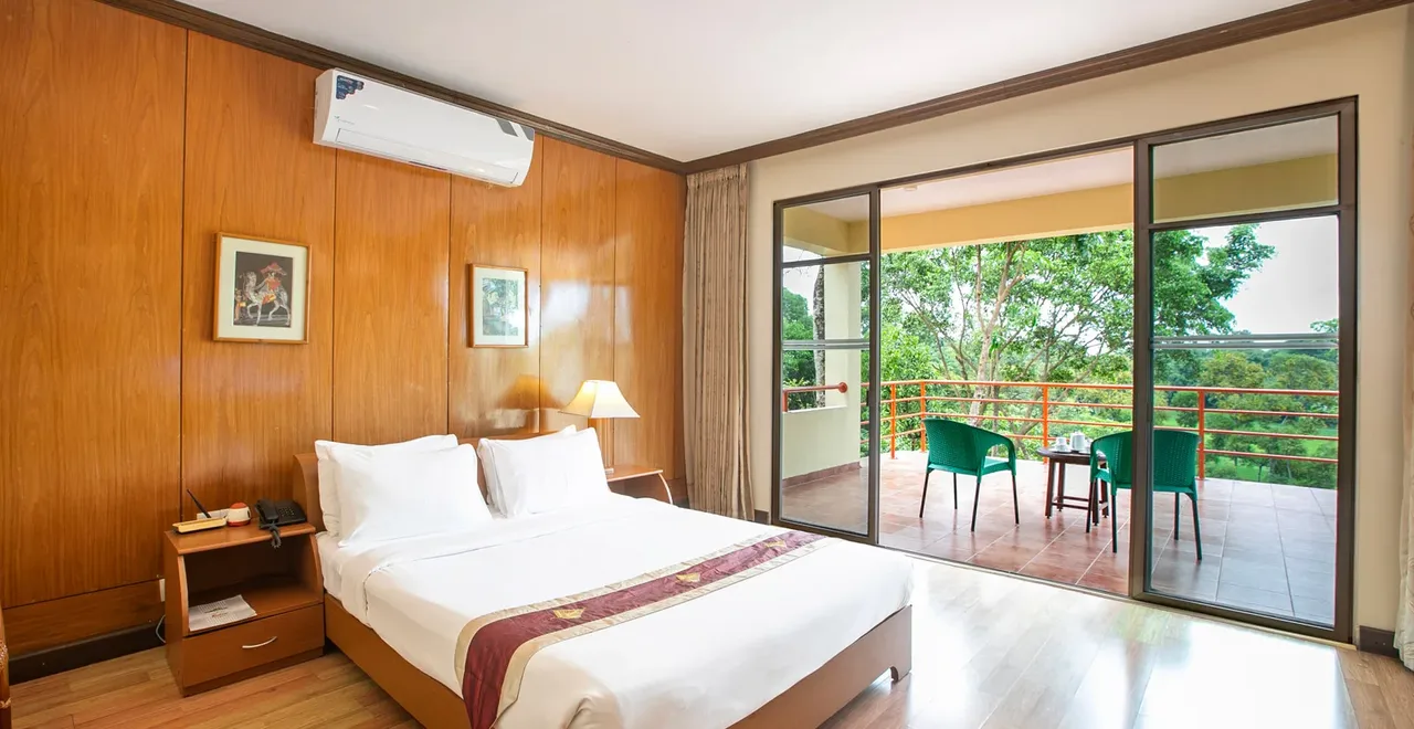 Deluxe room with balcony doors opening to trees