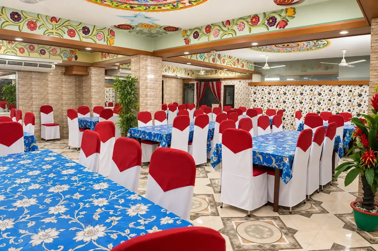 Dining hall with set tables and a patterned ceiling