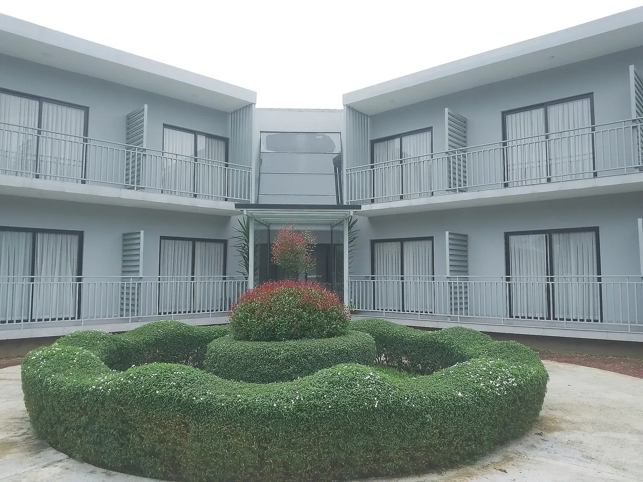 Two-storey room block around a clipped garden at Dream Square Resort