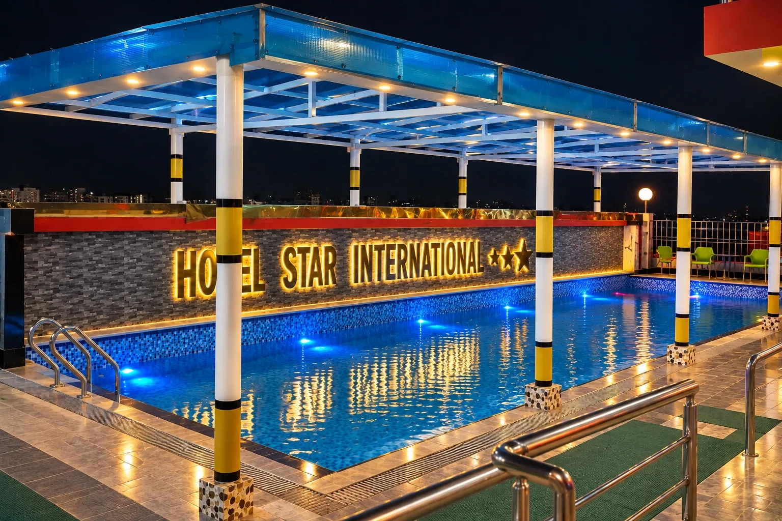 Swimming pool lit at night beside a sign reading Hotel Star International