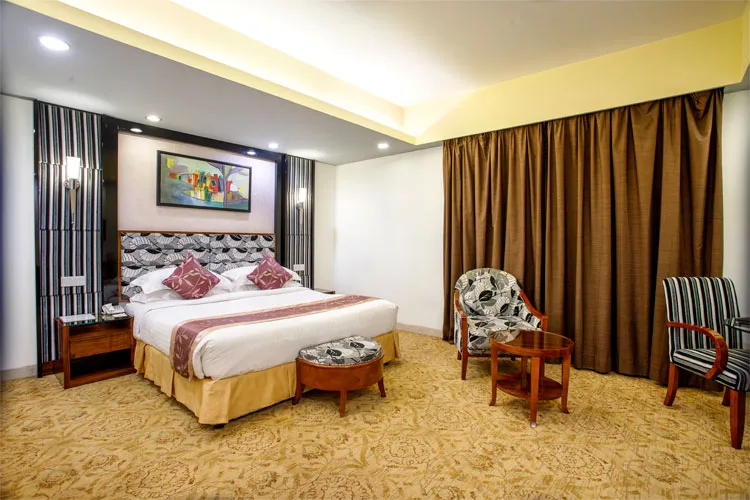 Executive suite bedroom with armchairs and curtains