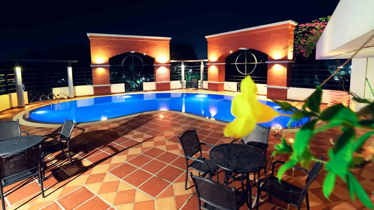 Rooftop swimming pool at night with brick arches behind