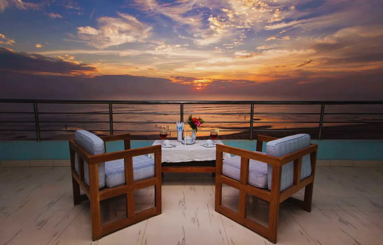 Balcony table set for two at sunset over the sea