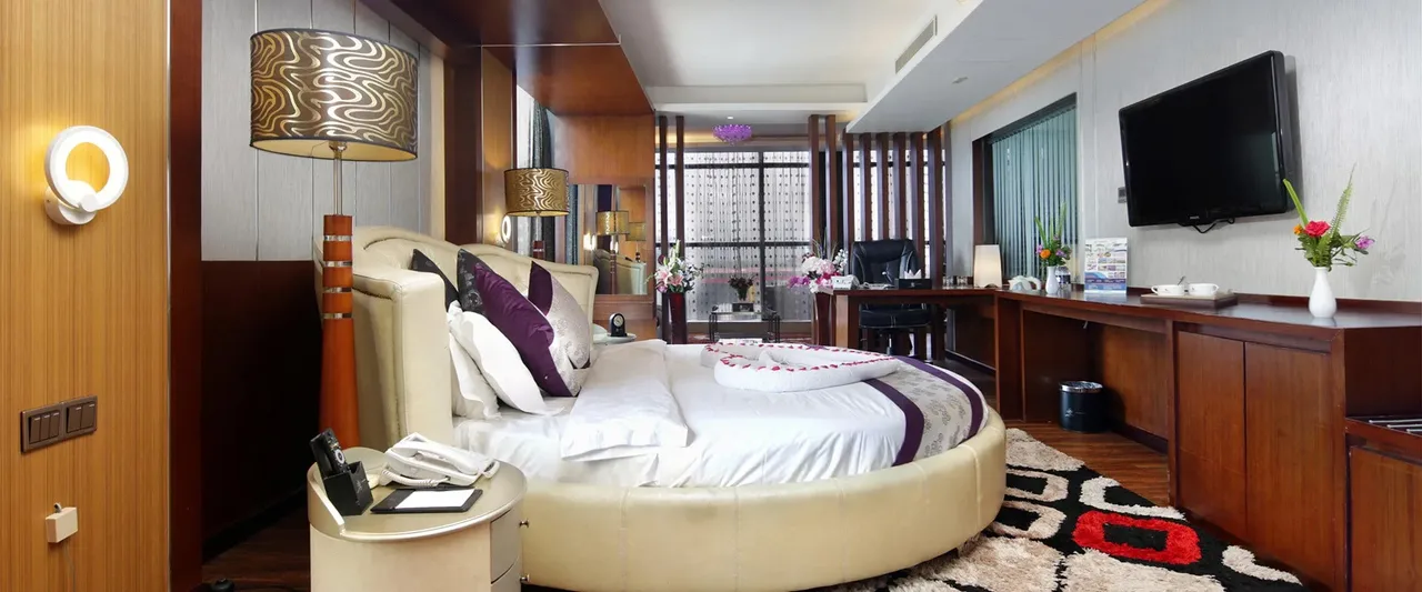 Guest room with a round bed and a long desk