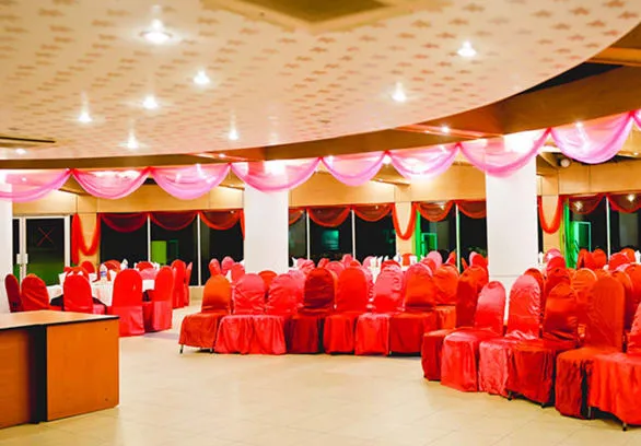 Event hall with red-draped chairs and a curved ceiling
