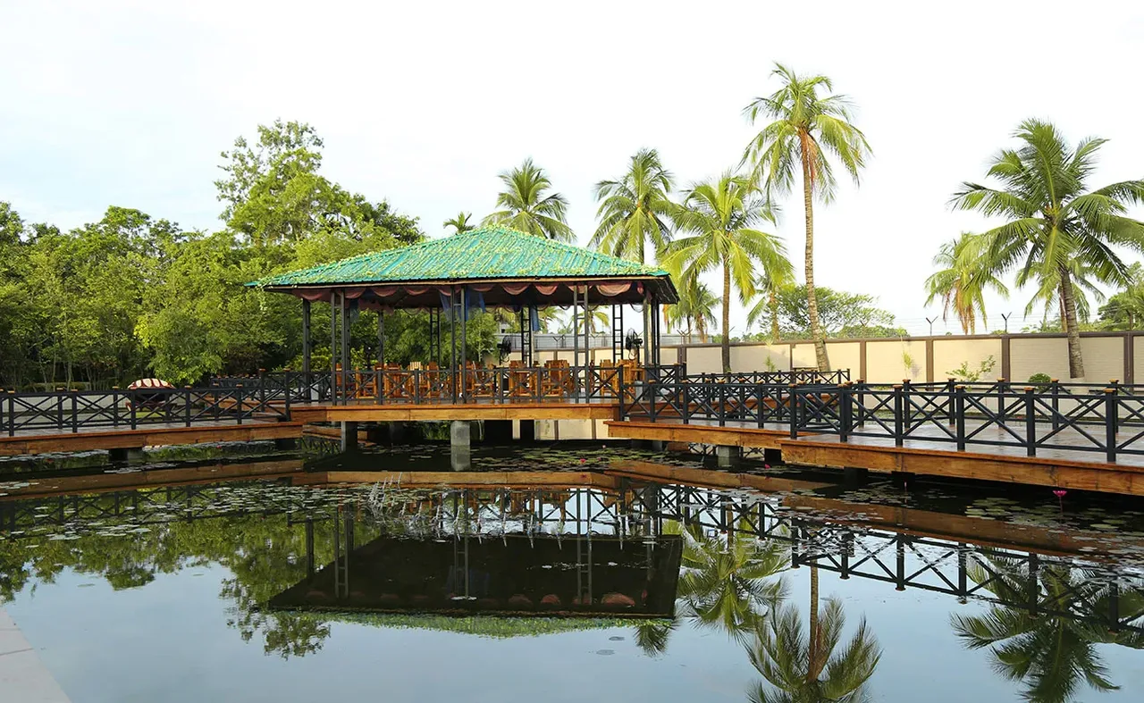 Wooden pavilion over a pond among palm trees