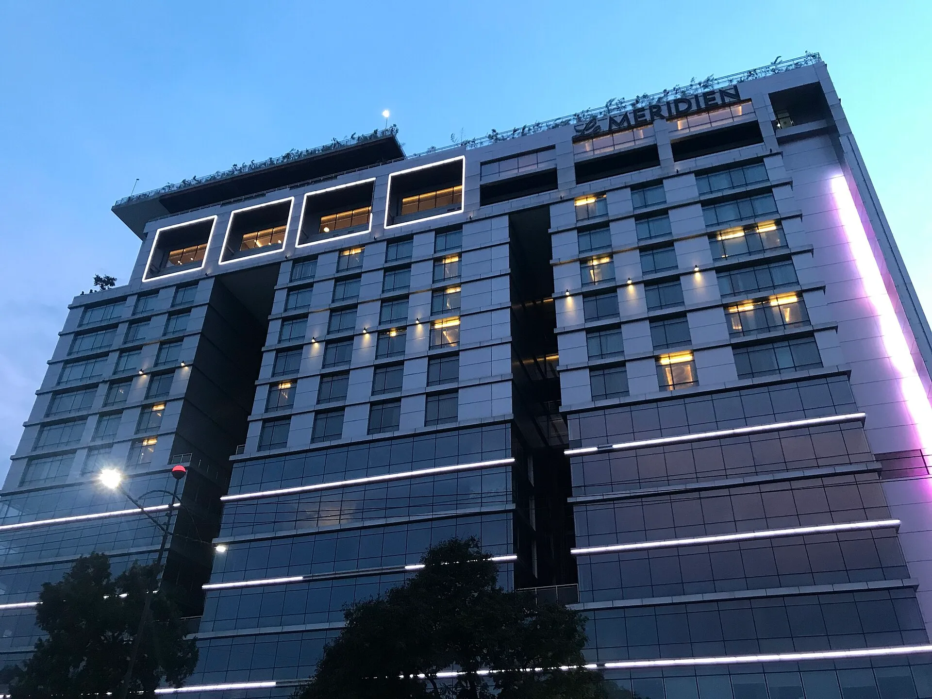 Le Méridien Dhaka facade at dusk with its lit rooftop sign