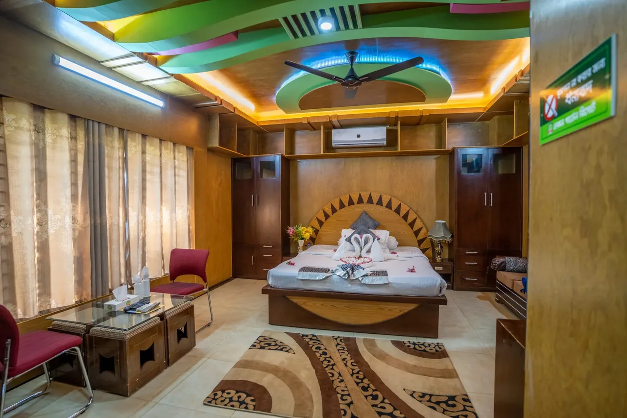 Deluxe room with a wooden headboard and cove lighting
