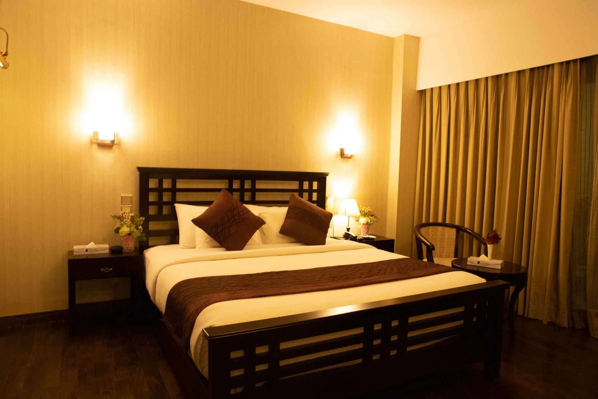Bedroom with a dark wooden bed frame and curtains at The Midori by Lakeshore