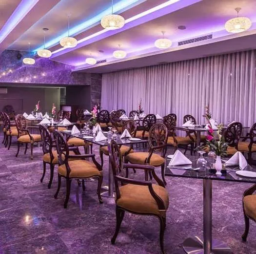 Restaurant hall with set tables and purple ceiling lighting