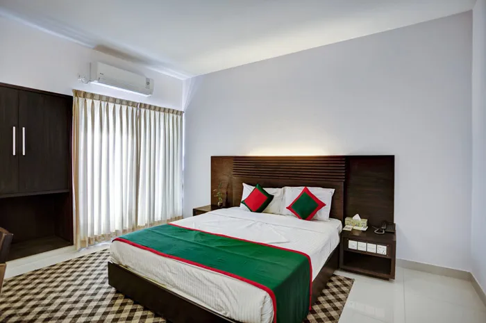 Guest room with a double bed in green and red linen