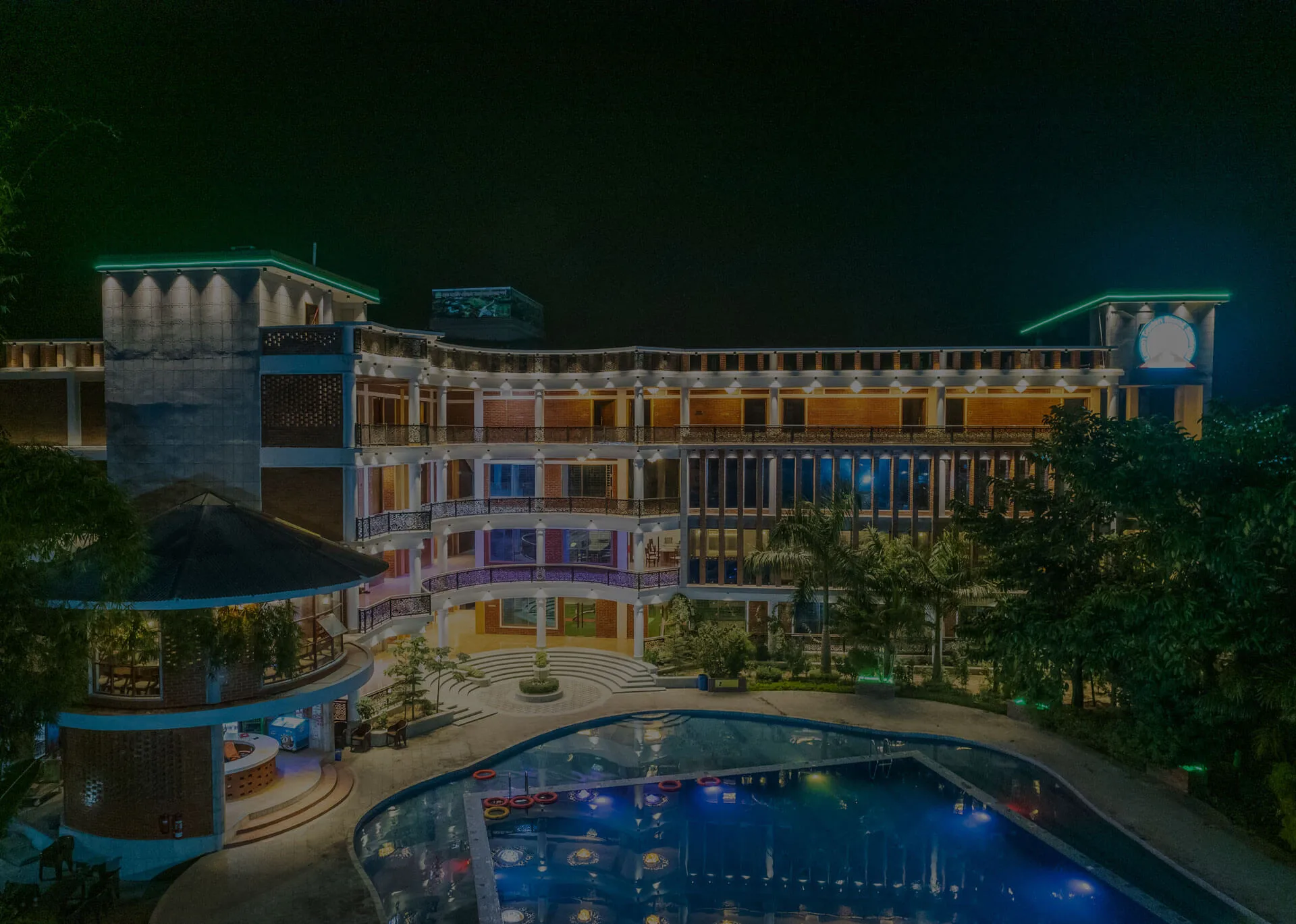 Resort building and swimming pool lit up at night