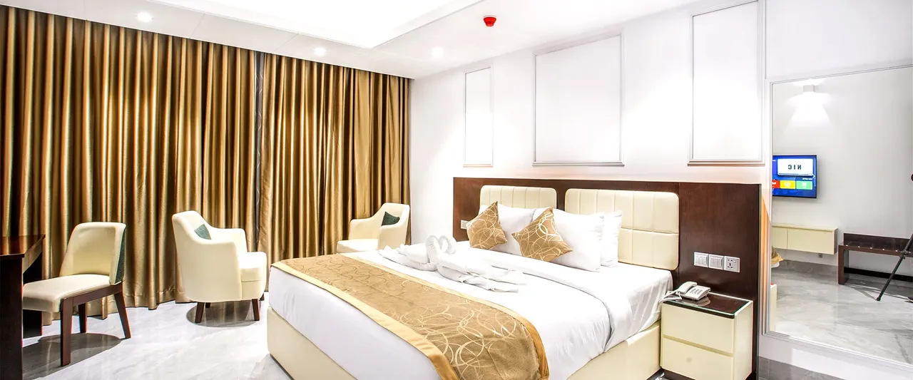 Super Deluxe King room with a double bed and armchair