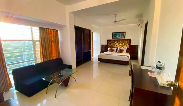 Guest room with a double bed, sofa and large windows